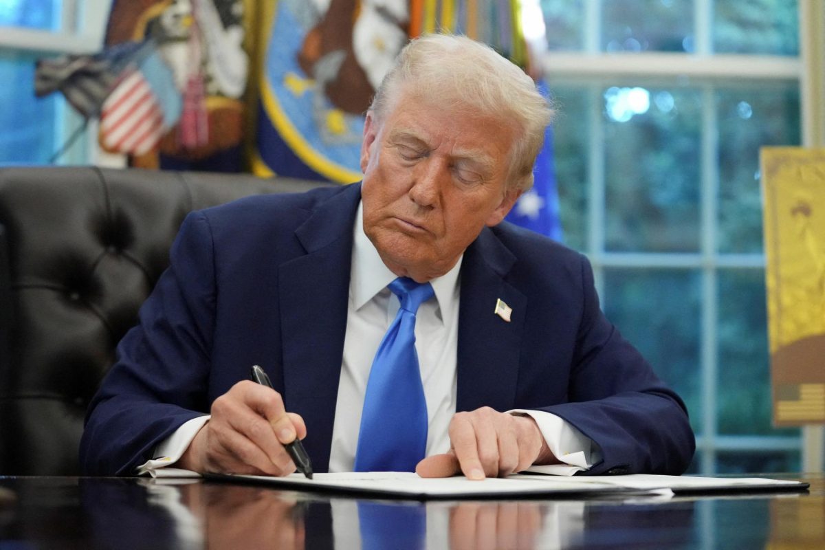 U.S. President Donald Trump signs an executive order in the Oval Office at the White House in Washington, D.C., U.S., September 19, 2025. REUTERS/Ken Cedeno