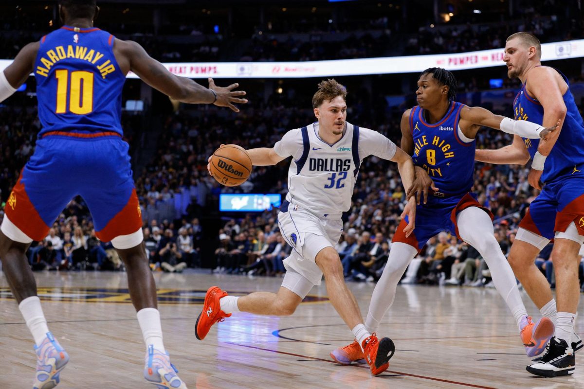 Dec 1, 2025; Denver, Colorado, USA; Dallas Mavericks forward Cooper Flagg (32) controls the ball against Denver Nuggets guard Peyton Watson (8) and center Nikola Jokic (15) as guard Tim Hardaway Jr. (10) defends in the fourth quarter at Ball Arena. Mandatory Credit: Isaiah J. Downing-Imagn Images