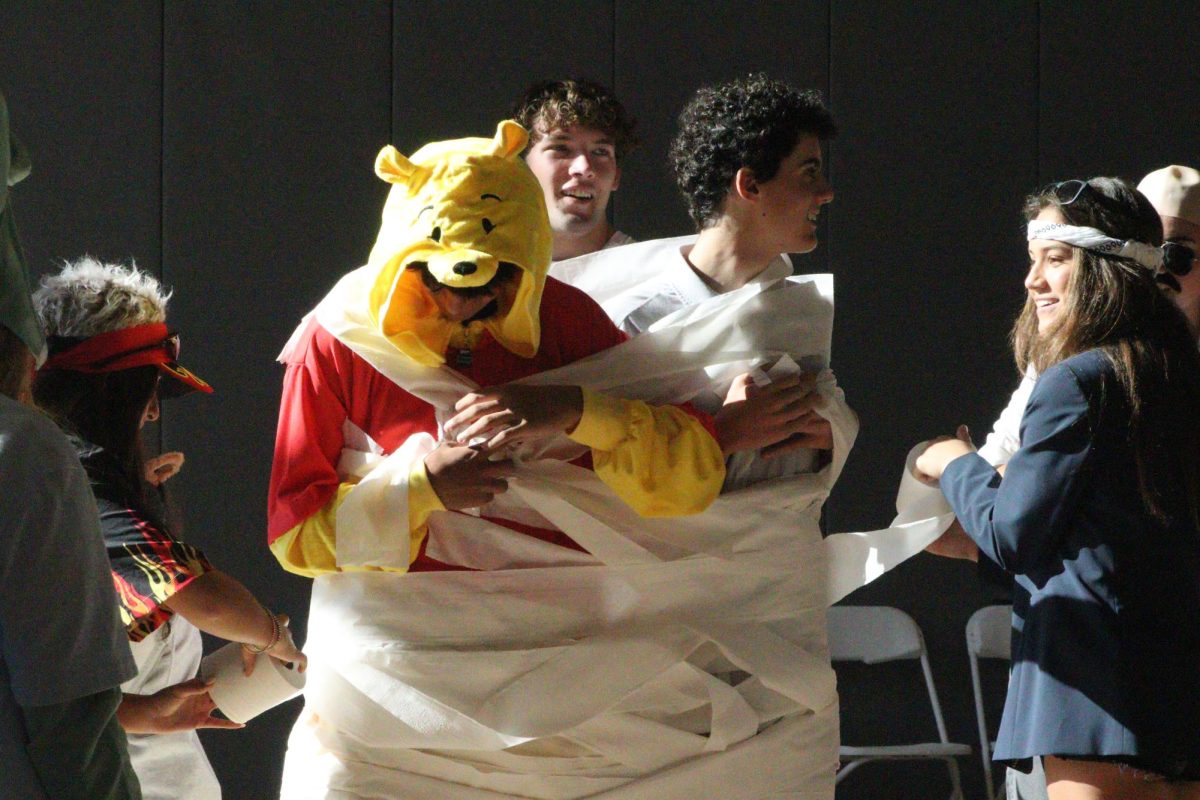 Students participate in a "mummy wrapping" activity during the Community Cohorts on Halloween.