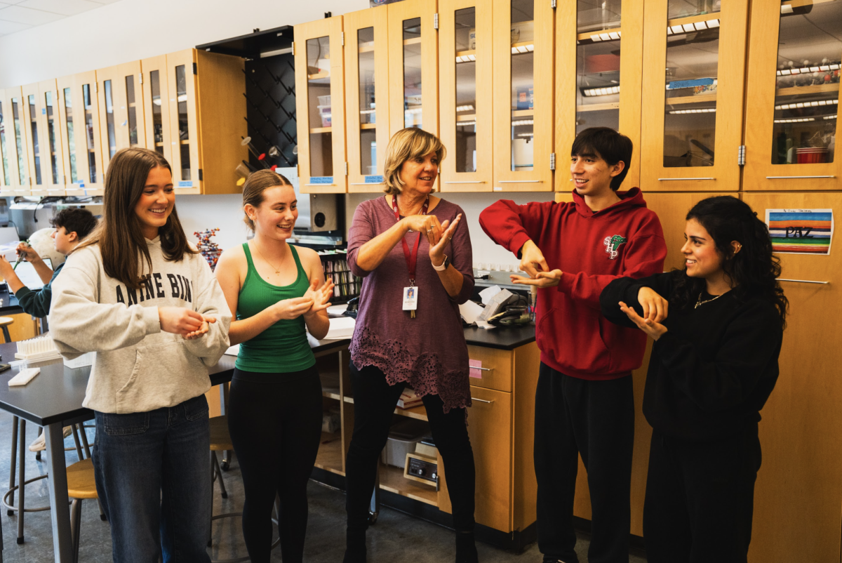 Science Co-Department Head Diane Sweeney helps students memorize the functions of proteins with hand signals // Photo provided by Sean Finnegan through Vidigami