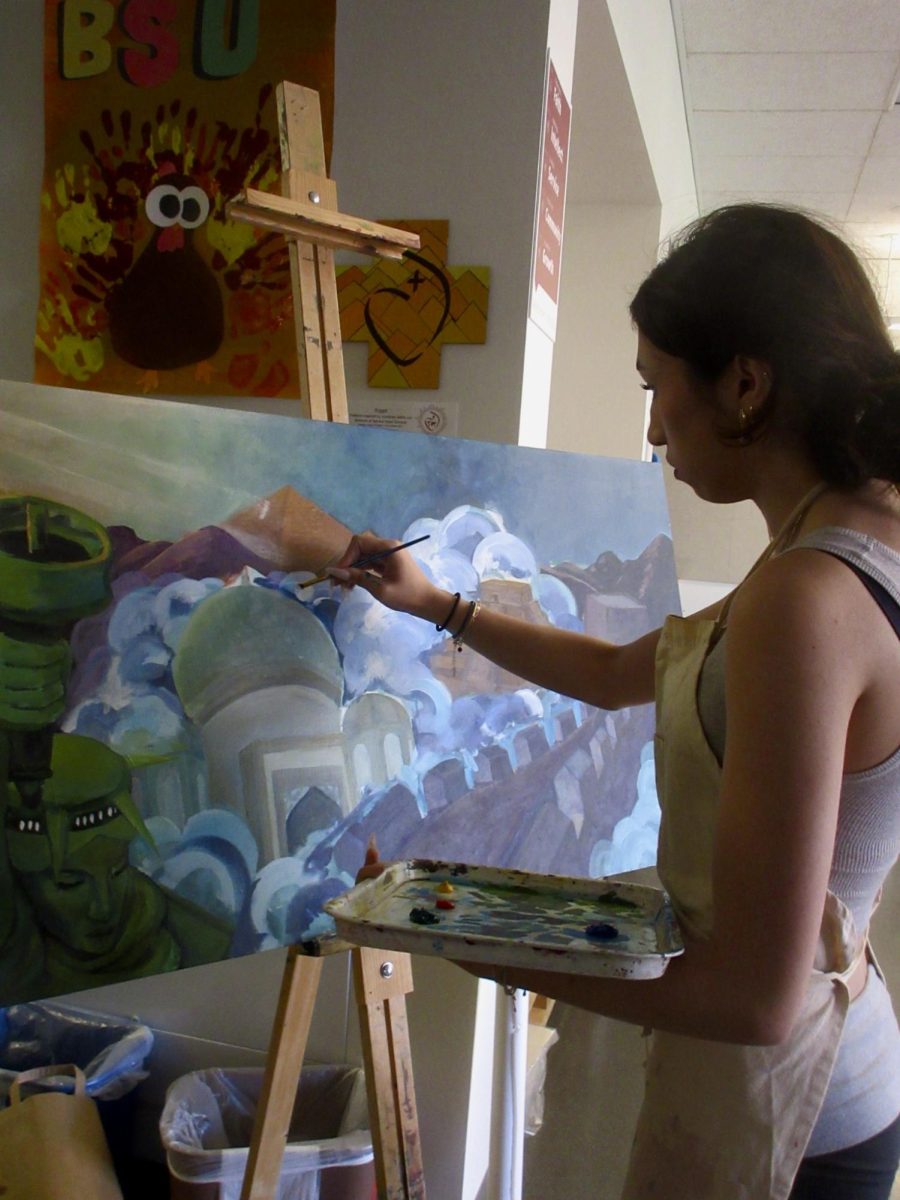 Evelyn Knestrick ‘26 embellishes her painting “Cinderella,” which explores solitude and isolation.